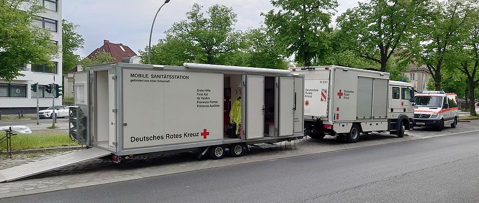 Zwei Sanitätscontainer hintereinander mit offenen Türen und einer lang ausgezogenen Rampe um Fahrtragen in den Container rollen zu können.