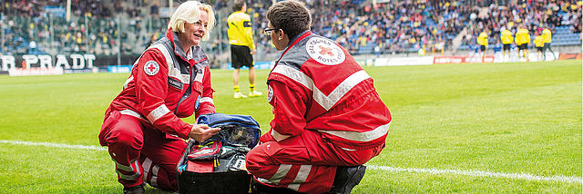 DRK- Bereitschaft, zwei Helfer im Fussballstadion